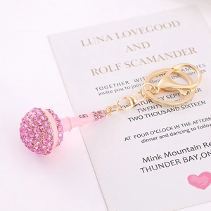 Close-up of pink microphone keychain with sparkling rhinestones and golden metal ring