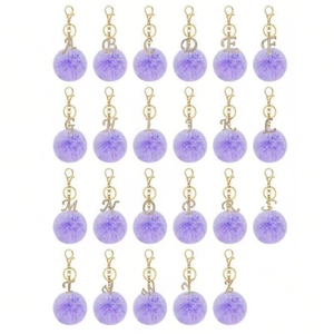 Detail view of purple faux fur ball keychains with gold rhinestone alphabet charms