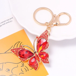 Macro shot of gold alloy butterfly keychain with sparkling red crystals and lobster clasp