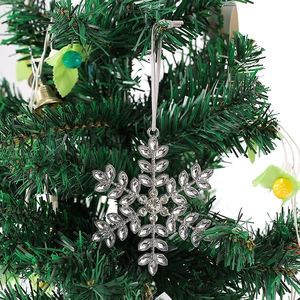 Close-up of sparkling silver rhinestone snowflake ornament hanging on a Christmas tree branch
