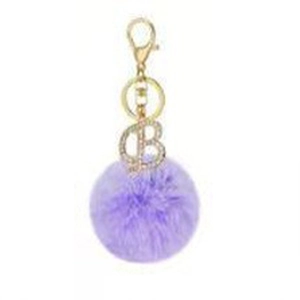 Detail of purple faux rabbit fur pompom keychain with gold rhinestone letter B charm