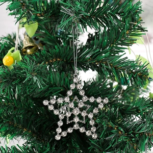 Close-up of sparkling rhinestone-encrusted star ornament hanging on a lush green Christmas tree