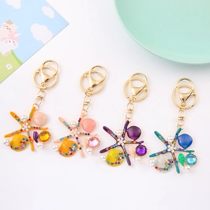 Porte-clés étoile de mer coloré avec strass et perles sur monture métallique dorée