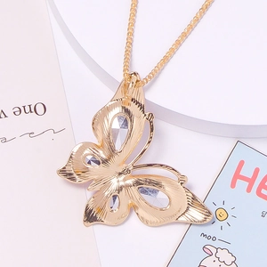 Macro detail of golden butterfly pendant featuring sparkling rhinestones on an alloy chain