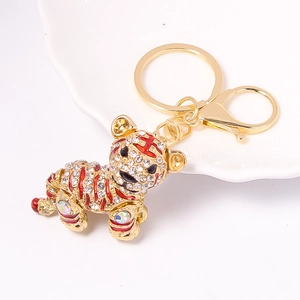 Detailed macro view of crystal-encrusted gold tiger keychain with red enamel stripes