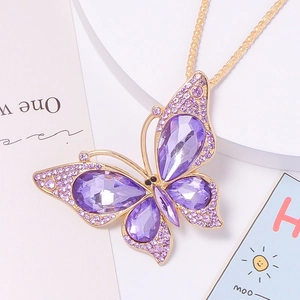 Macro detail of butterfly pendant with purple crystals and gold alloy metal chain