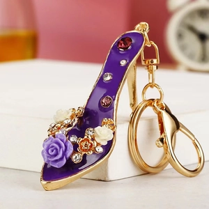 Close-up of purple enamel high heel keychain with floral resin clusters and rhinestones