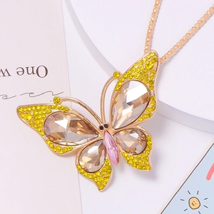 Macro detail of butterfly keychain with champagne crystals and golden metal finish