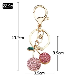 Sparkling pink rhinestone cherry keychain with golden lobster clasp and green leaf details