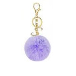 Close-up of purple plush faux fur pompom keychain with golden metal ring and spring clasp