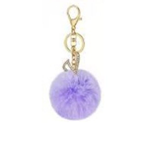 Detail of purple faux fur pompom keychain with golden rhinestone letter J pendant