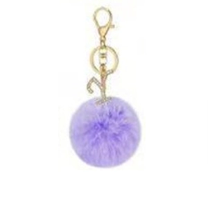 Close-up of purple faux fur pompom keychain with gold crystal letter Y pendant