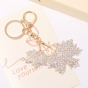 Gros plan du porte-clés feuille d'érable doré avec strass brillants et fermoir mousqueton