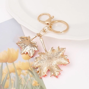 Porte-clés feuille d'érable doré avec double pendentif et texture métallique polie