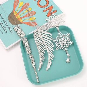 Detailed close-up of three silver Christmas tree ornaments with rhinestones and angel wings