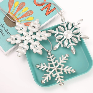 Three assorted silver metal snowflake ornaments with hanging loops for Christmas trees