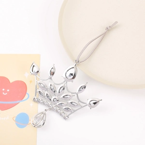 Close-up of silver crown pendant with clear rhinestones and gray suede hanging cord