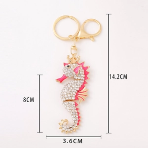 Sparkling seahorse keychain with white rhinestones, pink enamel, and gold crown detail