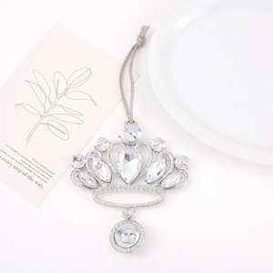 Detailed close-up of a silver crown ornament with sparkling rhinestones and grey hanging cord