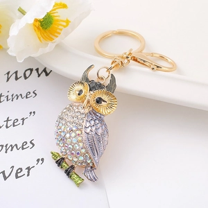 Détail du porte-clés hibou avec strass étincelants et ailes en émail dégradé