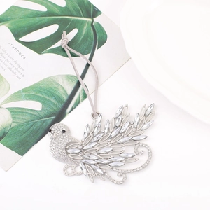 Detail of a sparkling silver hummingbird ornament with crystals and emerald accents