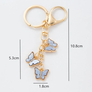 Elegant gold butterfly keychain with three light blue pendants and small diamond details