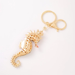 Golden seahorse keychain with hollow pattern and rhinestones on white background