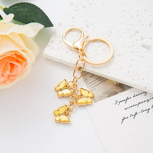 Detailed close-up of golden butterfly keychain with yellow marble charms and crystals