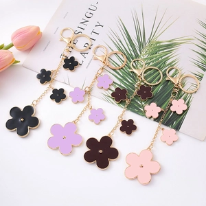 Detail of clover keychains in black, purple, brown, and pink with golden alloy chains
