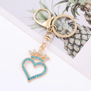 Detailed close-up of golden heart crown keychain with light blue rhinestones