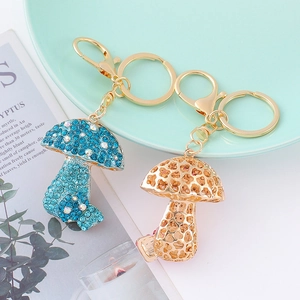 Creatieve paddenstoel sleutelhangers met blauwe strassteentjes en gouden opengewerkt design
