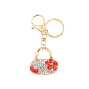 Golden handbag keychain with sparkling white rhinestones and red floral crystal accents