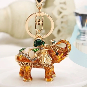 Detail of golden elephant keychain with colorful enamel, white gems and green crystals