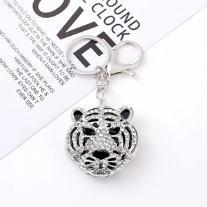 Macro shot of silver tiger head keychain with crystal rhinestones and black enamel details