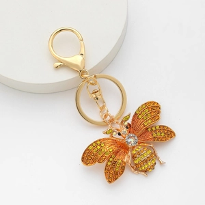 Porte-clés abeille dorée avec cristaux jaunes et fermoir mousqueton sur socle blanc