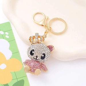 Close-up of sparkling crystal crown bear keychain with pink rhinestones on a white tray