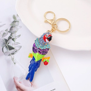 Detail of colorful parrot keychain with blue crystals and gold lobster clasp in flat lay view