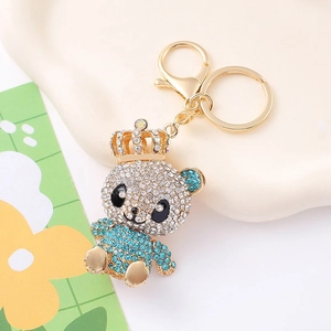 Detailed close-up of a crystal teddy bear keychain with gold crown and blue rhinestones