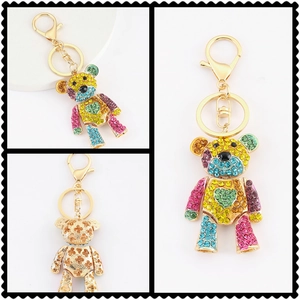 Detailaufnahme vom Teddy-Schlüsselanhänger mit bunten Strasssteinen und Goldkarabiner