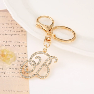 Macro view of gold-plated letter B keychain with shiny rhinestones and lobster clasp