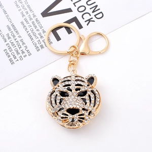 Golden alloy tiger head keychain with sparkling rhinestones and lobster clasp on white background