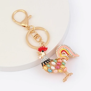 Detail of golden rooster keychain with colorful enamel, cat eye stone and white rhinestones