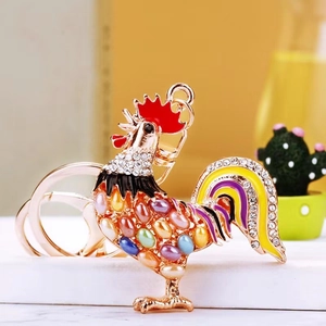 Macro detail of a rooster keychain with colorful imitation pearls and sparkling crystals