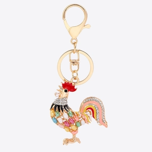 Close-up of golden rooster keychain with colorful enamel coating and sparkling rhinestones