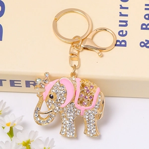 Close-up of golden elephant keychain with pink enamel, crown, and sparkling crystals