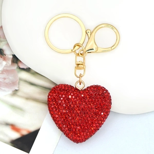 Dettaglio portachiavi a forma di cuore con strass rossi e chiusura in metallo dorato