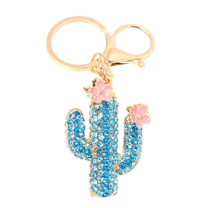 Exquisite gold cactus keychain with blue rhinestones and pink enamel flowers on white background