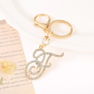 Detail of a sparkling gold-plated letter F keychain with rhinestones and lobster clasp