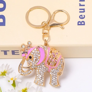 Close-up of golden elephant keychain with sparkling rhinestones and pink enamel crown detail