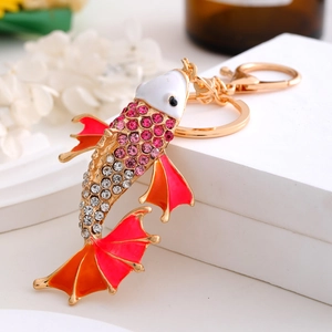 Modieuze koi vis sleutelhanger met roze strass steentjes op witte stenen display standaard
